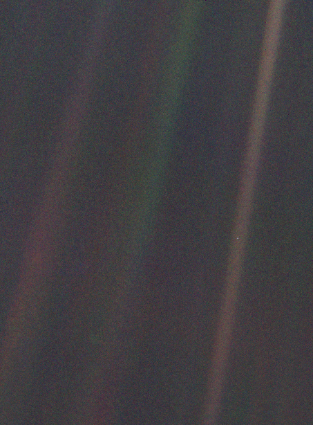 Sumuinen kuva, jossa Maa näkyy himmeänä sinisenä pisteenä avaruuden tyhjyydessä kaukaisuudessa.