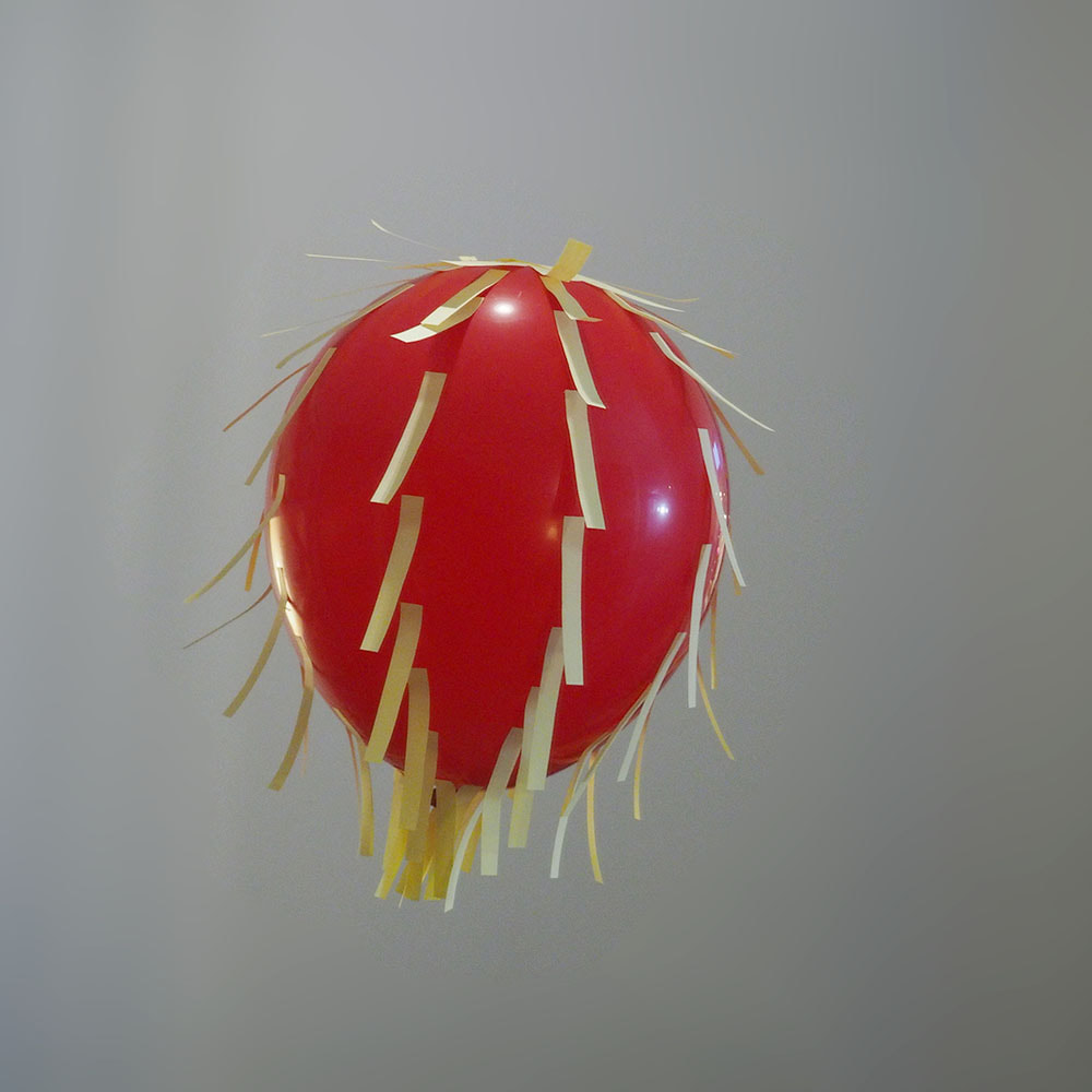 Punainen ilmapallo, johon on kiinnitetty post-it-suiroja demonstroimaan kampauskenttäviivoja.